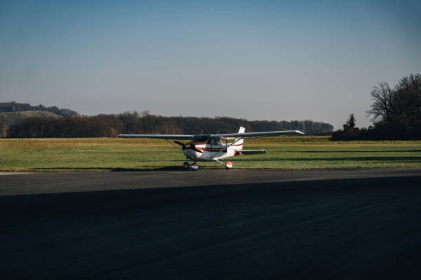 istock White and orange single propeller plane prepared before takeoff on the empty runway on a summer day 1904364902