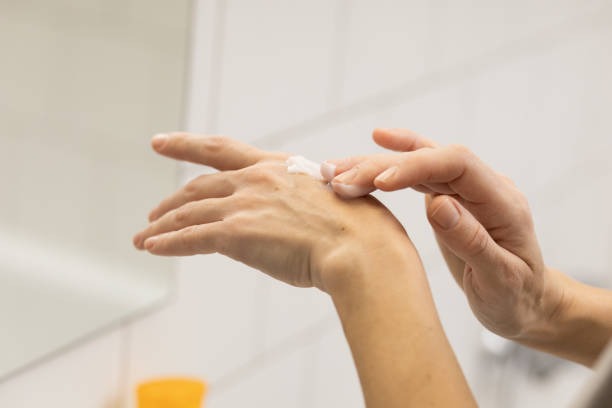 istock Woman in the bathroom using hand moisturizer 1904433158