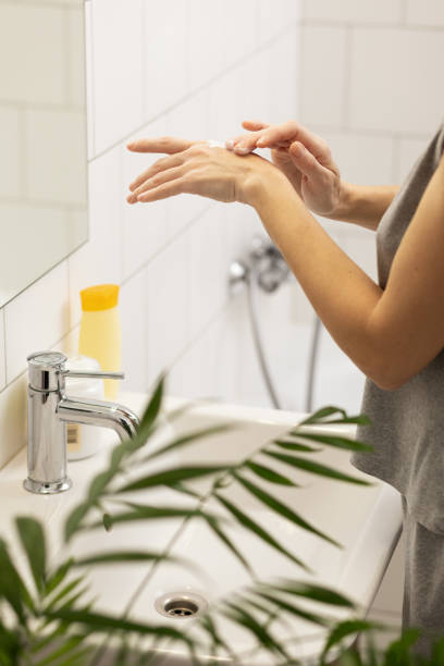 istock Woman in the bathroom using hand moisturizer 1904433632