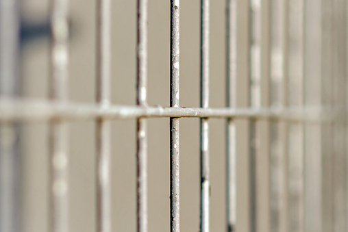 Gray metal vertical stripes fence. Abstract gray background. Closeup.