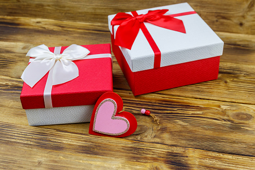 Gift boxes and red heart on a wooden background. Valentine's Day concept
