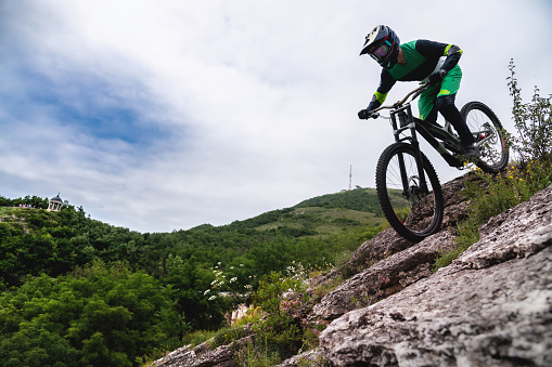 Sport. Cyclist against the sky. A young man rides a mountain bike in beautiful nature.Downhill, MTB. Extreme sport.