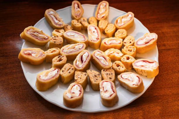 istock Sliced piece of cheese roulade on plate on table. 1904484674