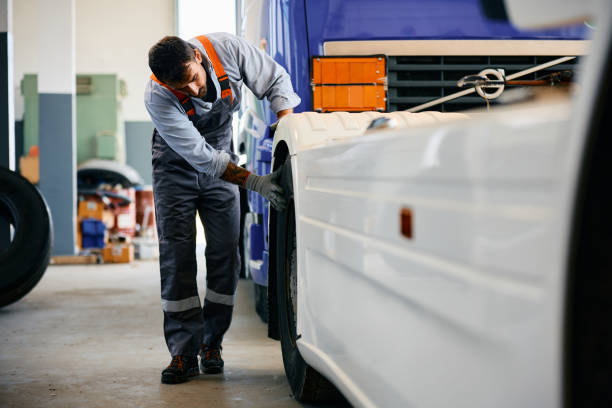 istock Mechanic checking truck tires while working in a garage. 1904497263