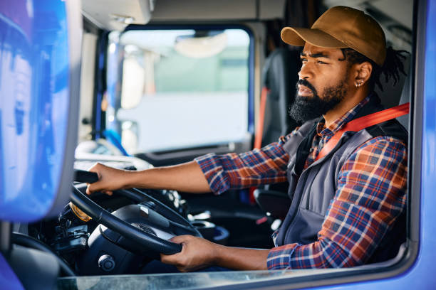 istock Black professional driver driving a truck. 1904501579