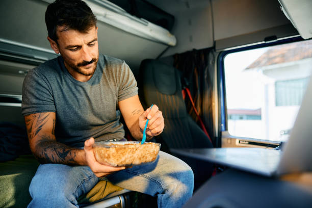 istock Professional truck driver having a lunch in a vehicle cabin. 1904504218
