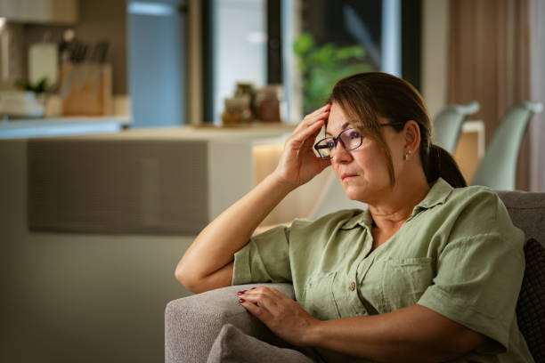 Portrait of worried thoughtful mature woman at home thinking about her problems stock photo