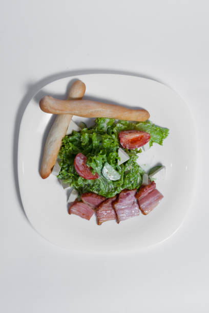 closeup lettuce with vegetable and bacon slice on white plate