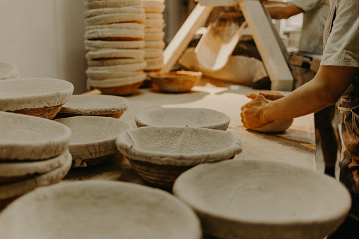 Female baker kneading dough in a bakery