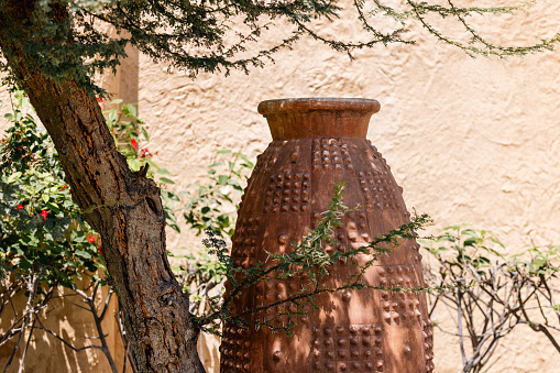 Ceramic clay pot with an ornament in the garden in UAE. High quality photo.