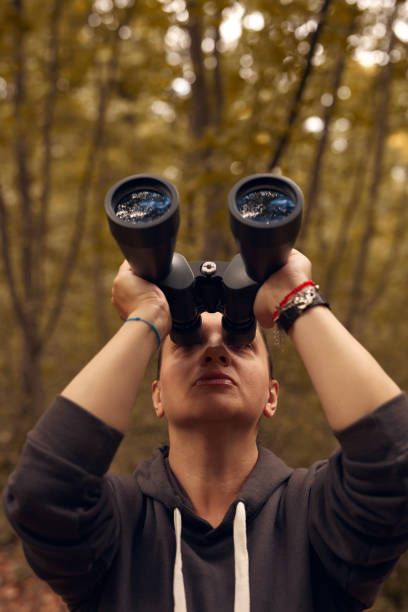 istock Woman using binoculars for birdwatching and observing other animals in nature. 1904562302
