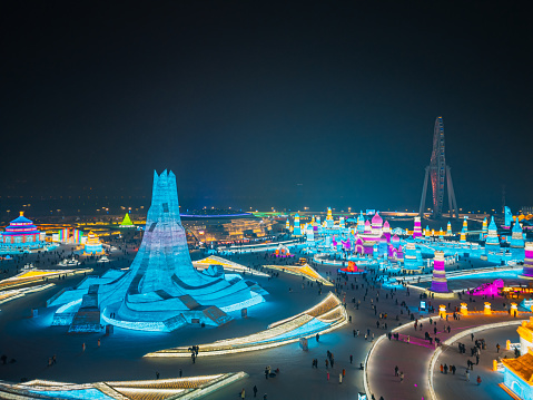 HARBIN, CHINA - DECEMBER 30: Aerial view of tourists visiting the 25th Harbin Ice and Snow World Amusement Park during winter night December 30, 2023 in Harbin, Heilongjiang Province of China