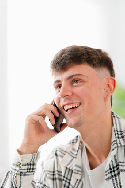 istock Handsome young man chatting with the mobile phone at home 1904622543