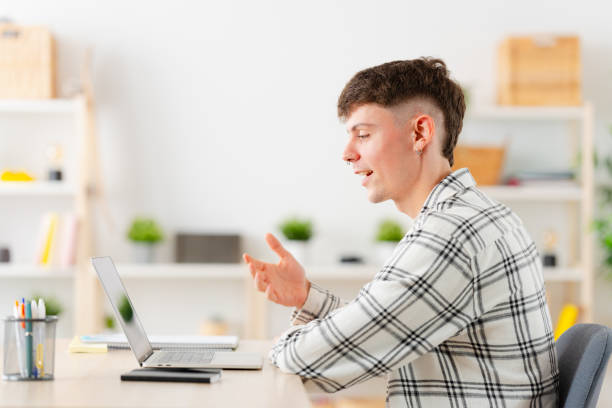 istock Young man talking during an online meeting from home 1904623054