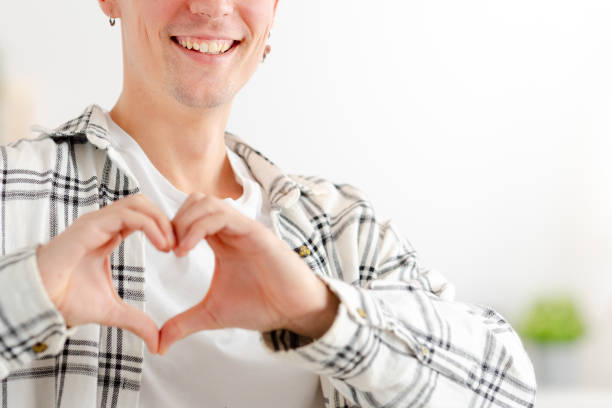 istock Close-up of a man gesturing heart with hands smiling 1904623067