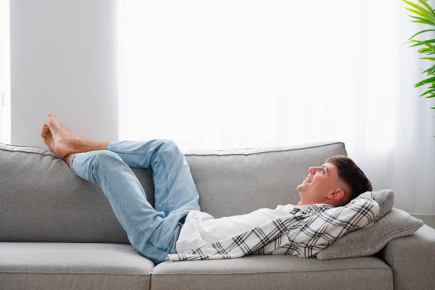 istock Relaxed man lying on the sofa smiling looking up 1904623083