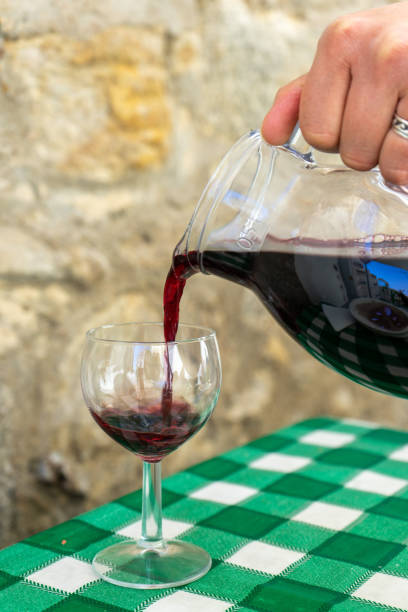 istock Pouring red wine from a glass pitche. 1904628381