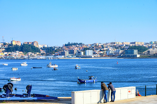 Porto, Portugal - Feb. 16, 2023: Tourists in the waterfront district by the Douro River.