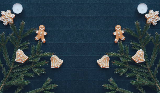 istock Symmetrical New Year's composition. Gingerbread, Christmas tree branches and candles are on a background of dark paper. Layout for the design. A place for the text. Flat Lay. Top View 1904711258