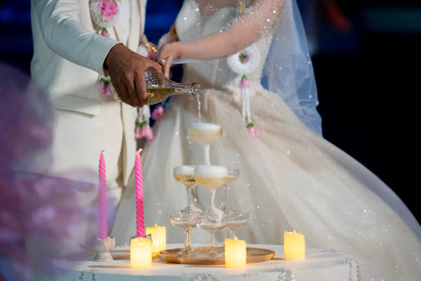 istock groom and bride together pour champagne At the wedding celebration 1904741409
