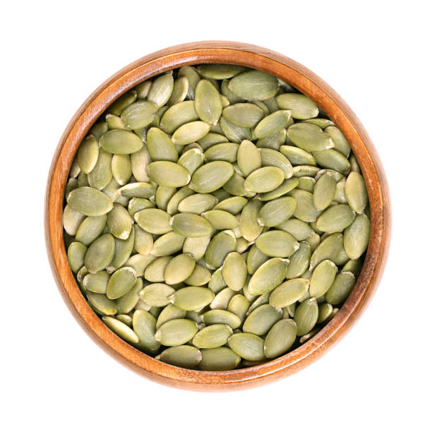 istock Pepitas, hulled pumpkin seeds after shelling, in a wooden bowl 1904774150