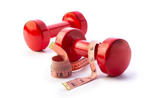 Brightly colored dumbbells with  a measuring tape. Isolated on a white background. Studio shot.