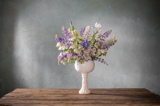 summer bouquet in white vase  on gray background