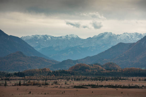 Panorama view over Murnauer Moos landscape with Bavarian Alp mountains during autumn, cloudy sky