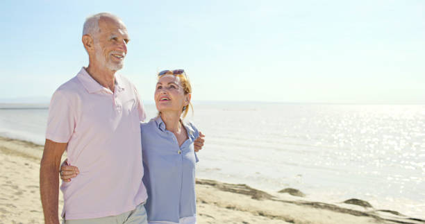 istock Senior couple walking on beach 1904868617