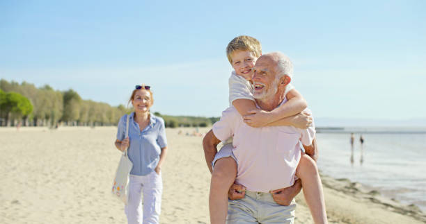 istock Man with his grandson walking on beach 1904868619