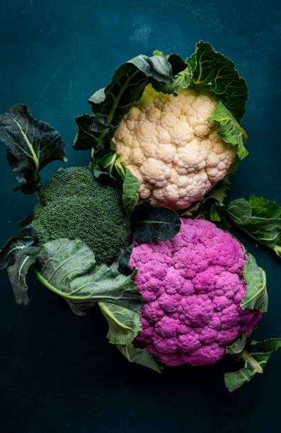 istock Purple and white cauliflower, broccoli cabbage from farm market on old rustic green table, top view 1904877141