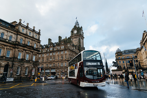 Edinburgh, UK - December 5, 2023: Princess Street during Christmas time a rainy day. Double decker bus