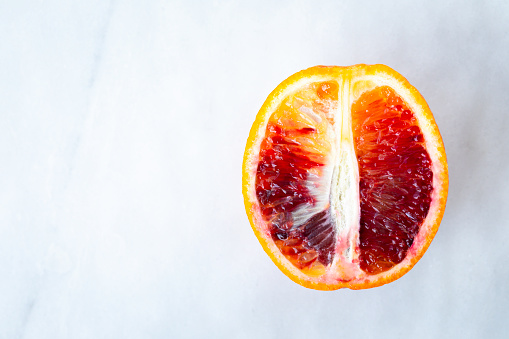 Cross section of one  blood orange on marbled background.