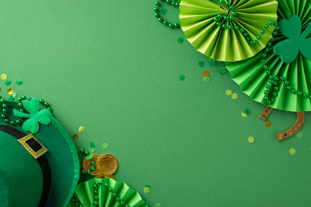 istock Saint Patrick's Day celebration in one frame: top view leprechaun's hat, fortunate horseshoe, glistening gold coins and more create lively scene on green backdrop. Advertise seamlessly with text space 1904963145