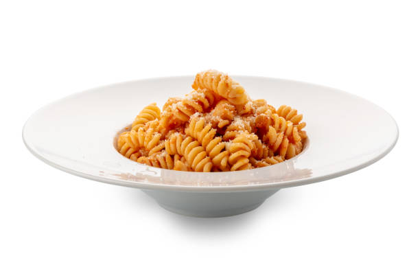 Pasta fusilli macaroni with tomato sauce and grated parmesan cheese in white plate isolated on white with clipping path included