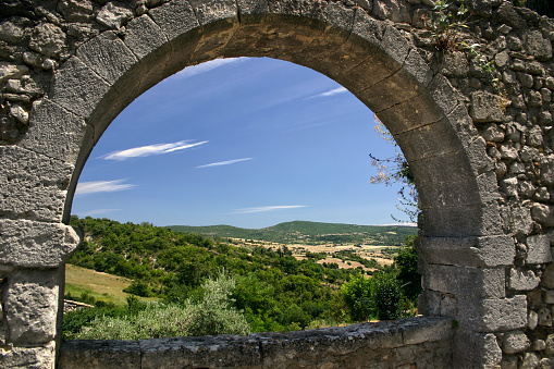 Countryside seen through an ancient stone archway