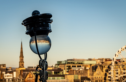 Edinburgh through water filled street lamp, with the city centre behind