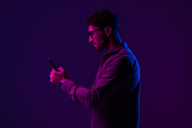 istock Male with smartphone on Red and blue neon light 1905046562