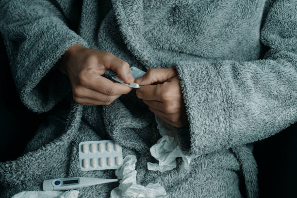 istock ill man in a robe about to take a pill at home 1905062579