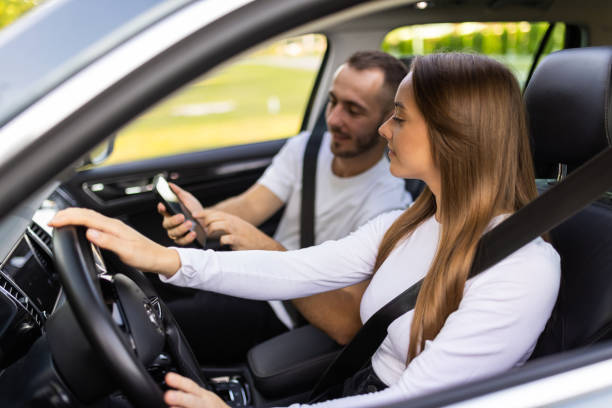 istock Couple driving and using phone in car enjoying road trip 1905066916