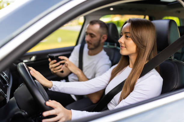 istock Couple driving and using phone in car enjoying road trip 1905077127