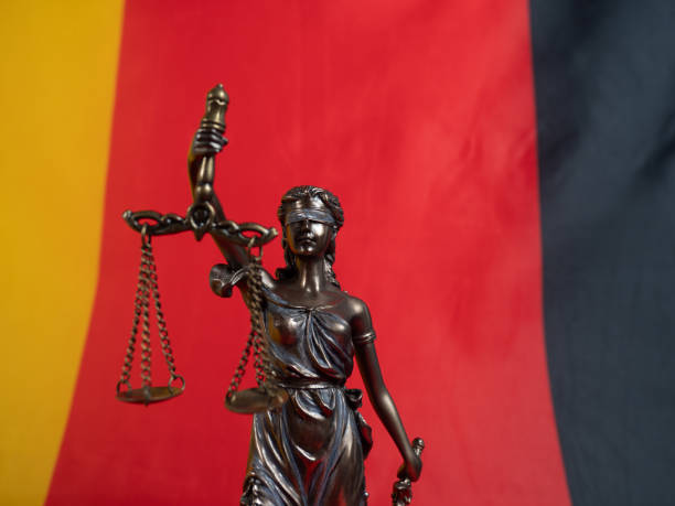 Bronze statue of justice with the German flag in the background. Bronze statue of justice with the German flag in the background. German law concept. civil rights act stock pictures, royalty-free photos & images