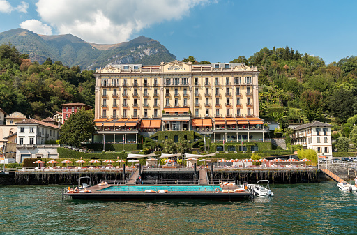 Tremezzina, Lombardy, Italy - September 5, 2022: View of the Luxury Grand Hotel Tremezzo with swimming pool on the shore of lake Como.