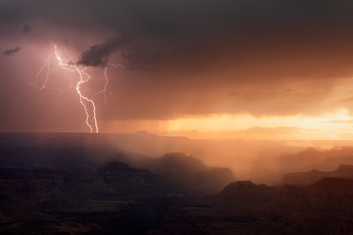 Lightning storm with dramatic clouds over the Grand Canyon at sunset.