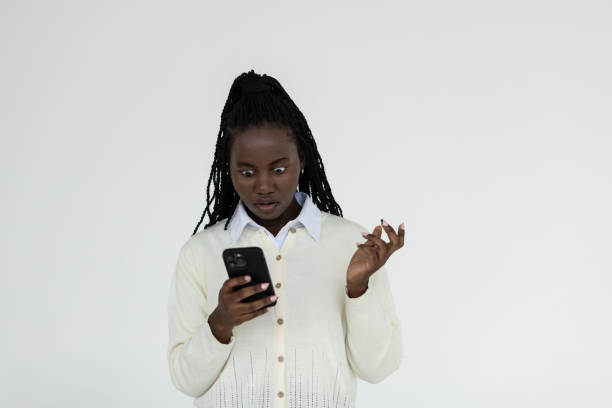 istock Attractive young african woman using smart phone on white background 1905151839