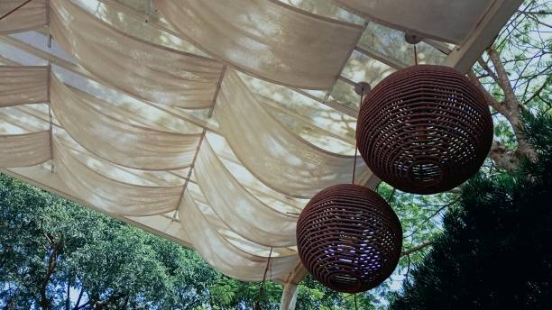 istock Tent with Cloths and Round Ceiling Lights Made from Rope. Natural Landscape with Trees 1905163595