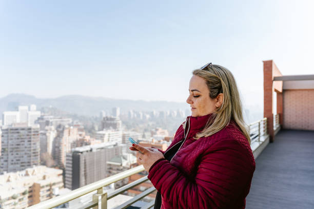 istock Woman using smartphone on building terrace 1905168490