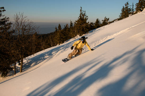 snowboarder masculino habilidoso que va cuesta abajo en la pendiente de las montañas. concepto de deporte de invierno - snowboarding extreme sports action snowboard fotografías e imágenes de stock