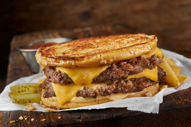 Copycat Grilled Cheese Burger on a Sesame Seed Bun Copycat Grilled Cheese Burger on a Sesame Seed Bun with American Cheese, Burger Sauce and Fries dill pickle stock pictures, royalty-free photos & images
