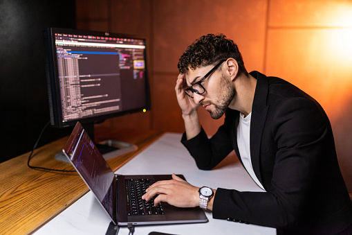 Young Smart Man Mobile Developer Writes Program Code On A Computer ...